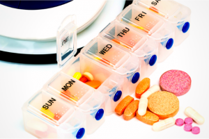 a photograph of a 7-day weekly pill organizer filled with pills